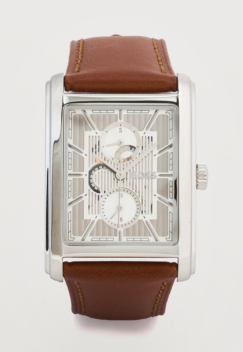 Ορθογώνιο ασημένιο ρολόι με λευκό σκελετό καντράν, δύο μικροί υποκαντράν, λογότυπο "BOSS" και καφέ δερμάτινο λουρί με ραφές.