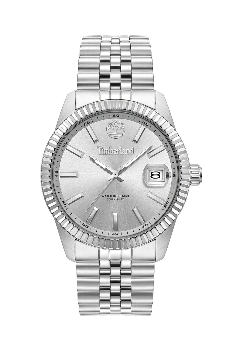 Reloj de acero inoxidable plateado con un dial texturizado, marcadores de hora luminosos, indicador de fecha y un bisel estriado. Resistente al agua hasta 50 m.