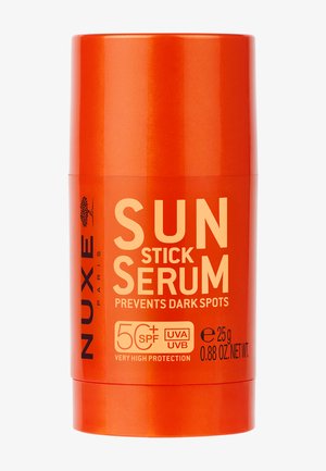 Oranje cilindrische NUXE Paris Sun Stick Serum met SPF 50+, UVA/UVB-bescherming, voorkomt donkere vlekken, 25 g (0,88 oz) netto gewicht.