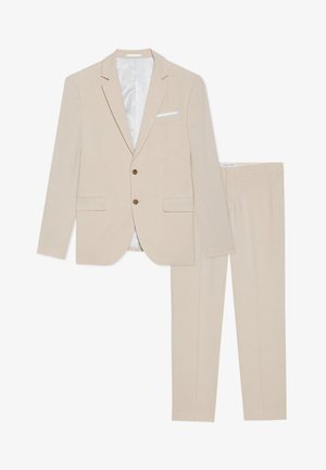 Beige ülikonnakomplekt, mis sisaldab kahe nupuga bleiserit, kõhude kraega ja sobivaid pükse. Valmistatud tekstuuriga kangast, millel on sile sisevooder.