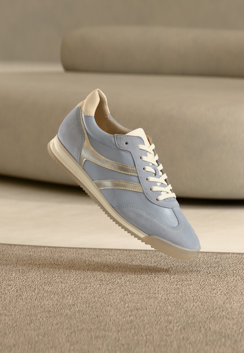 Baskets bleu clair en daim et cuir, accents crème, lacets blancs et semelle texturée. Design minimaliste avec des lignes épurées.