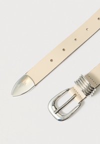 Ζώνη από μπεζ δέρμα με ασημένια μεταλλική αγκράφα και εξαρτήματα, με μυτερό άκρο και πολλαπλές τρύπες για ρύθμιση μεγέθους.