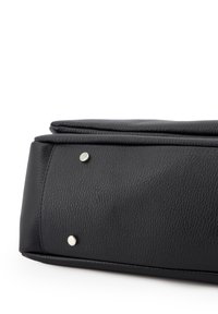 Sac en cuir noir avec une surface texturée, présentant une forme structurée et deux accents en métal argenté à la base.