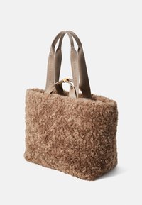 Vloeiende bruine tas met een zachte textuur, rechthoekige vorm en korte beige stoffen hengsels met reliëfbranding.