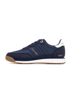 Zapatilla azul marino con una mezcla de materiales suaves y texturizados, con acentos dorados, lengüeta blanca en el talón y suela de goma con un dibujo en zigzag.