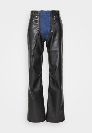 Pantalons large en simili cuir noirs avec un insert en denim bleu à l'avant. Dotés d'une fermeture éclair et de accents en métal.