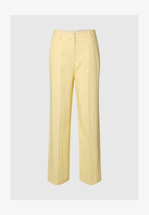 Lysegule bukser med lige ben, bæltestropper og frontlynlås på ensfarvet baggrund.
