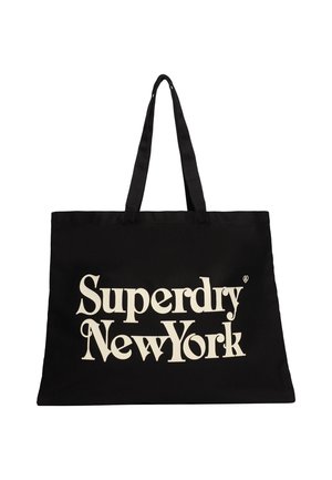 Zwarte draagtas met twee handvatten, voorzien van de tekst "Superdry New York" in grote crèmekleurige stijl op de voorkant.