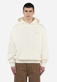 Cream-colored hooded sweatshirt with a front pocket, ribbed cuffs, and hem. Small embroidered logo on the chest, made from soft fabric.