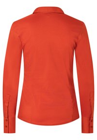 Langearmige shirt in een levendige oranje kleur, gemaakt van zachte stof. Kenmerkt zich door een klassieke kraag en knoopmanchetten met een getailleerde achterkant.