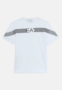 Hvit T-skjorte med korte ermer og svarte horisontale striper over ryggen og armene, med "EA7"-tekst sentrert på den øvre delen av ryggen.