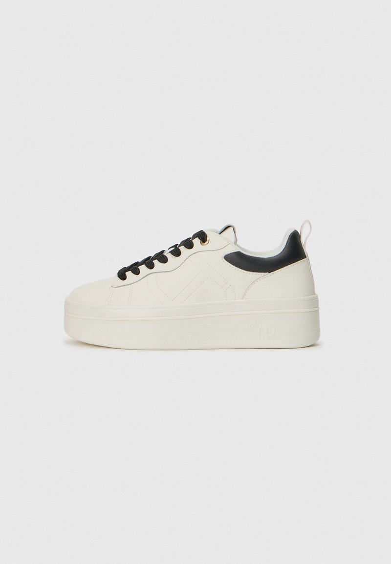 Sneaker platform bianche con accenti neri, caratterizzate da pelle testurizzata, punta rotonda e lacci in tessuto. Suola liscia con dettaglio del marchio.