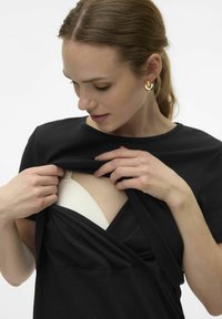 Robe noire avec un design enroulé, manches courtes, montrant un sous-vêtement blanc. Texture lisse avec des rayures subtiles et un décolleté profond.