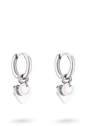 Boucles d'oreilles en argent avec un pendentif en forme de cœur. Le pendentif présente un texte gravé, et le design comprend une finition lisse et polie.