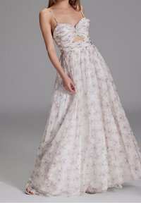 Abito maxi floreale con scollo a cuore, spalline sottili e una apertura in vita. Realizzato in un tessuto leggero e fluente in colori pastello.