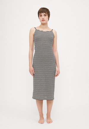 Abito a righe bianco e nero con spalline sottili, silhouette aderente, lunghezza al ginocchio, realizzato in un tessuto texturizzato. Senza accenti particolari.