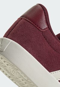 Burgundijske tenisice od ante materijala, s kožnim petnim kapom, bijelom gumenom potplatom s teksturiranim gripom i kontrastnim detaljem šivanja.