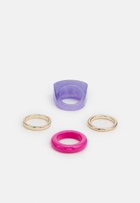 Conjunto de quatro anéis: um anel transparente roxo, duas alianças douradas brilhantes e um anel sólido rosa. Vários formatos e acabamentos.