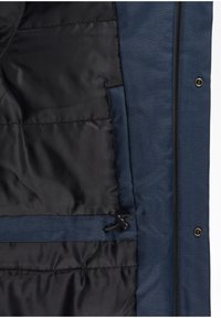 Veste bleue avec doublure matelassée noire, cordon de serrage ajustable à l'intérieur, et fermetures éclair et boutons-pression visibles.
