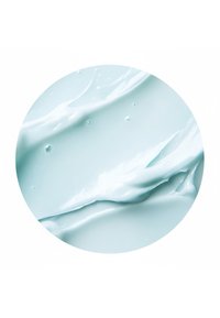 Texture lisse de crème ou gel bleu clair avec de petites bulles d'air, montrée en gros plan circulaire.