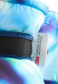 Barevná polstrovaná tkanina s přechodem modré a fialové. Obsahuje suchý zip a štítek 3M Thinsulate pro izolaci.
