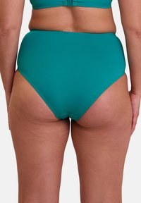 Bas de maillot de bain taille haute en teal uni avec un matériau lisse et extensible. Le design présente une coupe épurée et des coutures minimales, améliorant le confort.
