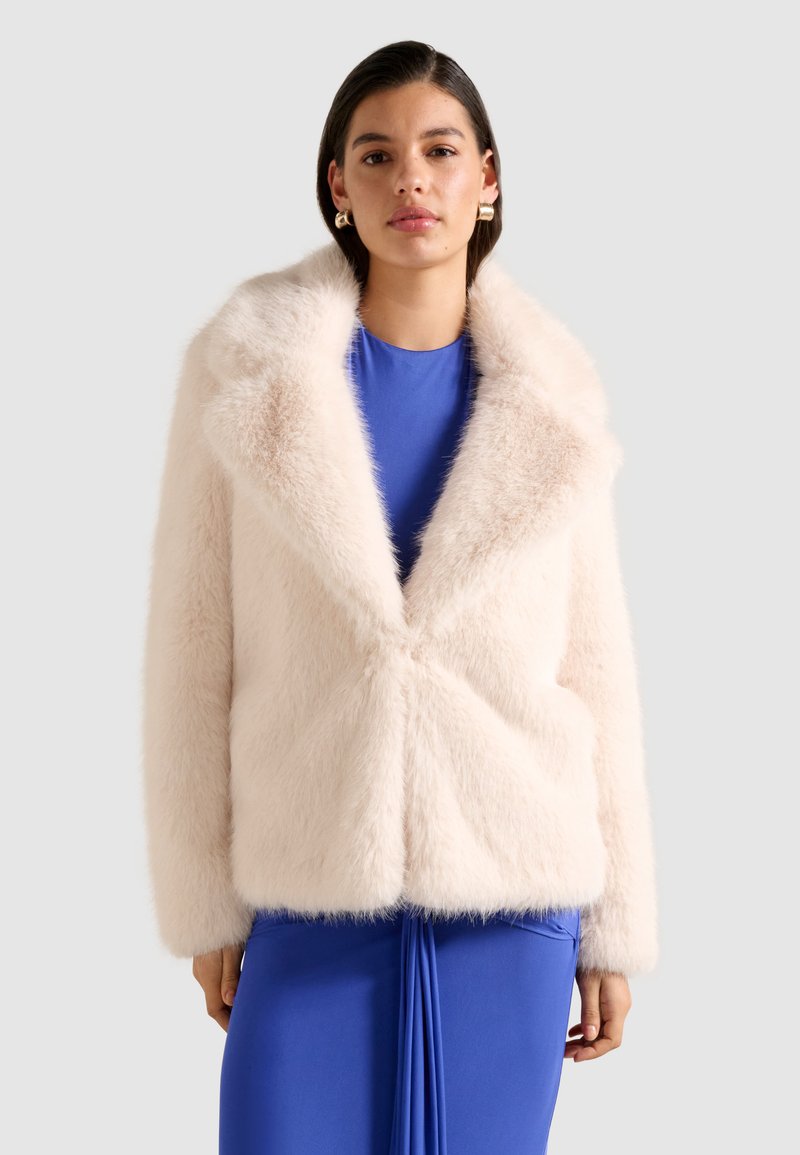 Luftig, lyserød faux fur jakke med sjalskrave, lukning med knapper foran og lange ærmer, båret over en blå kjole.