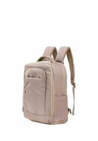 Beżowy plecak wykonany z trwałego materiału, wyposażony w przednią kieszeń, wyściełane paski z siateczki oraz prostokątny kształt z zamkami błyskawicznymi.