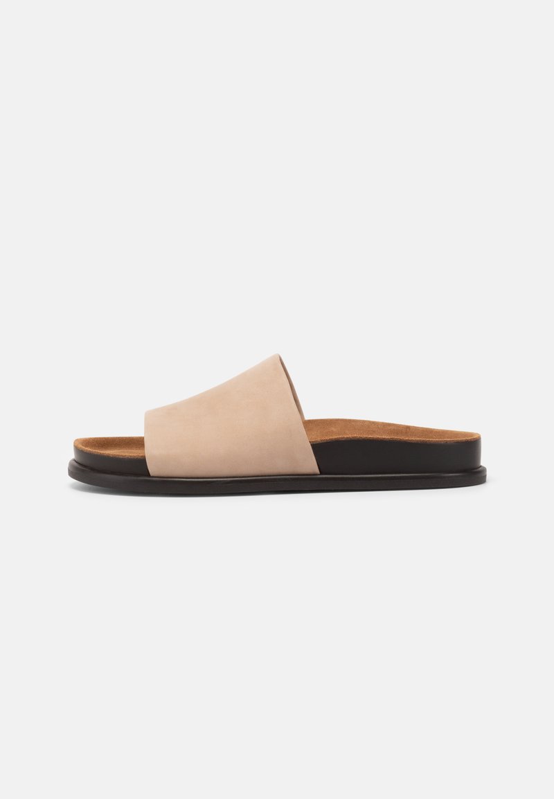 Beige suede slide sandal with a wide strap and brown cushioned footbed; features a black bottom sole for durability.