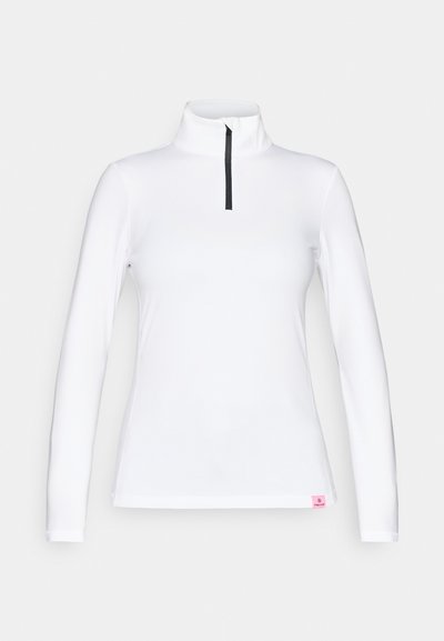 Λευκή μπλούζα με μακριά μανίκια και ψηλό γιακά, με μαύρο μισό φερμουάρ. Διαθέτει μία μικρή ροζ ετικέτα στο ποδόγυρο. Λείο και ελαστικό υλικό.