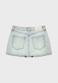 Mini-jupe en denim bleu clair avec poches arrière, passants pour ceinture et étiquette de marque blanche sur la ceinture, posée à plat sur un fond gris.