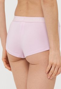 Ροζ βαμβακερά σορτς hipster με απαλό λάστιχο που φέρει την επωνυμία "PIECE." Λείο άγγιγμα και κλασικό σχέδιο κοπής.