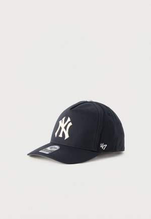 Navy blue baseball cap with white New York Yankees logo embroidered on front and '47 brand logo on side, displayed on plain white background.
