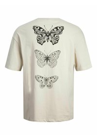 Cream cotton t-shirt featuring three detailed black illustrations of butterflies on the back, with short sleeves and a crew neck design.