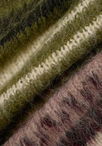 Textil, das eine Mischung aus olivgrünen, cremefarbenen und gedämpften rosa Fasern zeigt. Enthält strukturierte, flauschige Oberflächen mit sichtbaren Farbübergängen und Mustern.