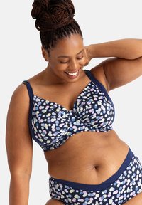 Námornícky modrá podprsenka a nohavičky s bodkovaným vzorom v pastelových farbách. Obsahuje nastaviteľné ramienka a hladký materiál.