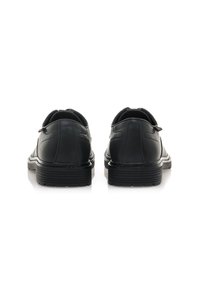 Schwarze Lederhalbschuhe mit matter Oberfläche, runder Zehenpartie und kontrastierender texturierter Gummisohle, die subtile Nähdetails aufweisen.