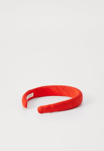 Red fabric headband with a smooth texture, featuring a contoured shape. No visible embellishments or notable details.