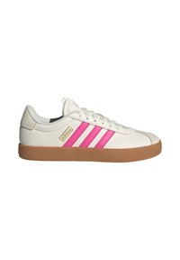 Baskets basses Adidas blanches avec semelle gomme et bandes roses sur le côté, dotées de lacets blancs et d'un petit logo Adidas doré.