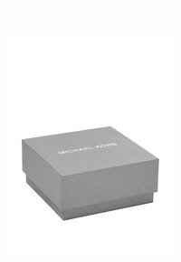 Scatola regalo grigia con texture e coperchio, caratterizzata da un logo bianco in rilievo "MICHAEL KORS" centrato sulla parte superiore. Forma rettangolare.