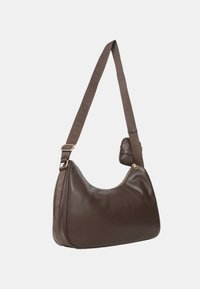 Borsa a spalla in pelle marrone con ampia tracolla regolabile e piccolo pouch attaccato, dotata di chiusura a zip in cima su uno sfondo neutro.