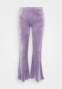 Lila velourbyxor med utsvängd nederdel, elastiskt midjeband och subtil Adidas-logotyp på vänster lår, visade på vit bakgrund.