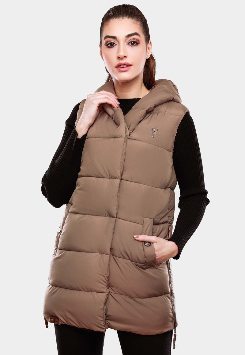 Beige Steppweste mit Kapuze, ausgestattet mit einem gesteppten Design, seitlichen Taschen und besticktem Logo. Getragen über einem schwarzen Pullover.