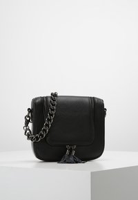 Borsa a tracolla nera in pelle con finitura testurizzata, tracolla a catena, patta frontale e dettaglio a frangia sulla cerniera. Forma rettangolare compatta.