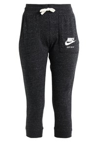 Černé melírované tepláky s opaskem na stažení, dvěma bočními kapsami a bílým logem Nike s textem "JUST DO IT" na pravé kapse.