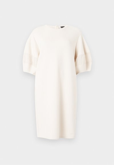 Φόρεμα μήκους έως το γόνατο σε κρεμ απόχρωση με κοντά φουσκωτά μανίκια και στρογγυλή λαιμόκοψη, παρουσιασμένο σε απλό ανοιχτό γκρι φόντο.