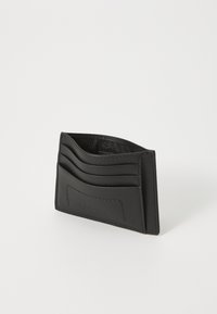 Svart lær kortholder med tre framside lommer, en jevn tekstur og en subtil preget logo. Kompakt og minimalistisk design.