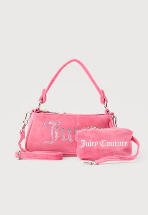 Deux sacs Juicy Couture roses, un plus grand avec des lettres en cristal et une poignée, un plus petit avec des lettres blanches et une lanière de poignet, sur un fond gris.