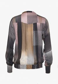 Durchscheinende Bluse mit langen Ärmeln und einem mehrfarbigen Zickzackmuster in Schwarz-, Pink- und Beigetönen; elastische Bündchen und geraffter Saum.