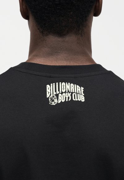 Μαύρο βαμβακερό T-shirt με λευκό λογότυπο "Billionaire Boys Club" και γραφικό αστροναύτη στο πίσω μέρος του λαιμού. Απλός σχεδιασμός με στρογγυλή λαιμόκοψη.